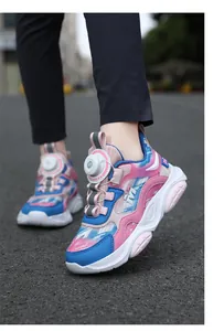 Primer plano de zapatillas rosas y azules para niñas con cierre de dial en asfalto.