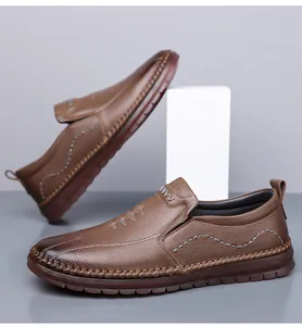 Seitenansicht brauner Leder-Slipper mit dekorativen weißen Kontrastnähten und weicher Sohle.