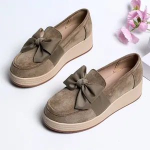 Detailansicht braune Plateau-Loafer aus Wildleder mit eleganter Schleife auf Weiß