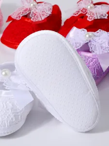Close-up of the non-slip soft sole on these elegant lace newborn baby shoes with bow