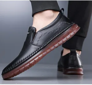 Nahaufnahme von schwarzen Herren-Slippern aus echtem Leder mit brauner weicher Sohle