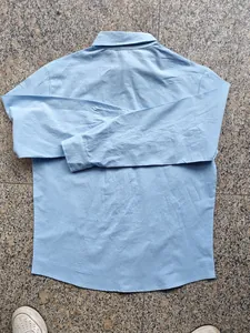 Vue arrière d'une chemise décontractée à manches longues en lin bleu clair pour homme.
