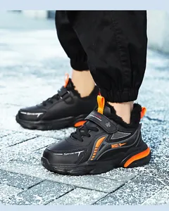 Detail view of black boys' winter running shoes with orange accents and warm fur lining