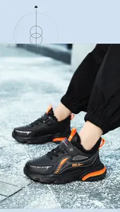 Macro view of boys' waterproof black sneakers with orange stripes and warm fur lining