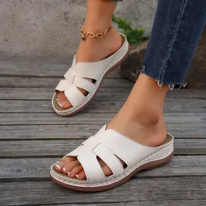 Primer plano de sandalias blancas con plataforma para mujer en una cubierta de madera