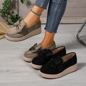 Detailaufnahme von Plateau-Loafers mit dekorativer Schleife in Khaki und Schwarz