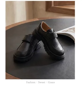 Detail view of boys' black British style leather shoes with Velcro straps for school.