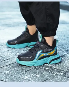 Close-up of boys' waterproof running shoes with turquoise soles and warm fur lining.