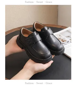 Detailed view of classic black leather boys' school shoes with convenient strap closure