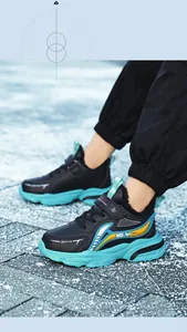 Detailed view of black boys' sneakers with turquoise soles and warm fleece lining