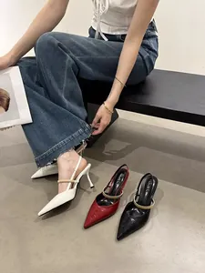 Detail view of French style pointed-toe slingback heels in white, red and black.