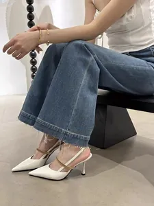 Elegant white pointed-toe slingback high heels with metallic gold strap on model