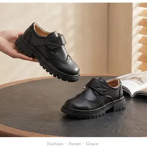 Classic black boys' leather school shoes with velcro straps and elegant brogue details