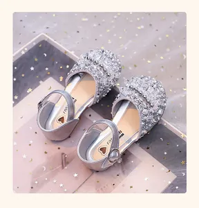 Gros plan de chaussures de princesse argentées pour filles avec strass et perles