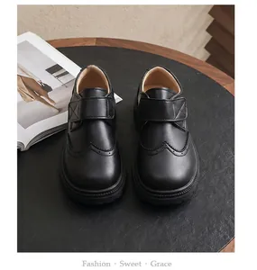 Detailed view of boy's black British style school leather shoes with Velcro straps.