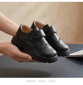 Detail showing the classic brogue wingtip pattern and velcro strap of kids' leather shoes