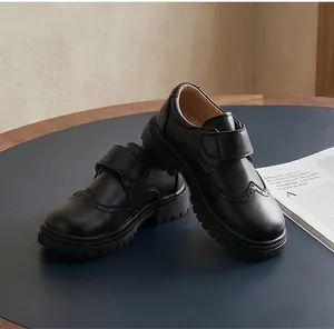Detailed view of black British style boys' leather shoes with elegant brogue wingtip patterns