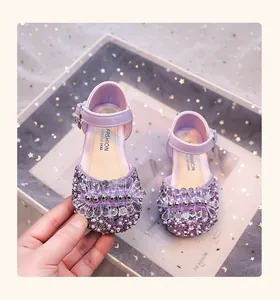Gros plan sur des chaussures de princesse violettes à strass et perles pour filles