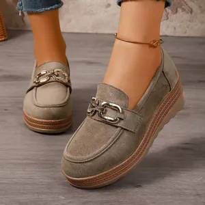 Nahaufnahme von olivgrünen Wildleder-Plateau-Loafers mit eleganter Goldkettendekoration.
