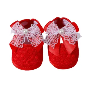 Red soft sole newborn baby girl walking shoes with white lace bow and pearl accent.