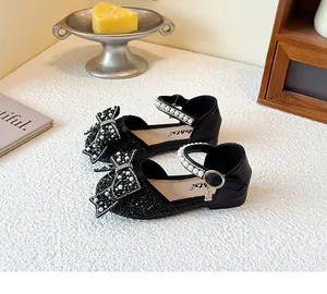 Detailansicht der schwarzen Prinzessinnenschuhe für Mädchen mit Perlschleifen.