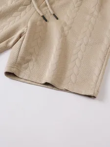 Close-up detail of beige men's casual shorts showing premium jacquard cable knit texture