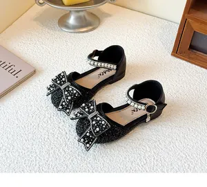 Elegante Detailansicht der schwarzen Paillettenstruktur von Mädchenschuhen mit Schleife