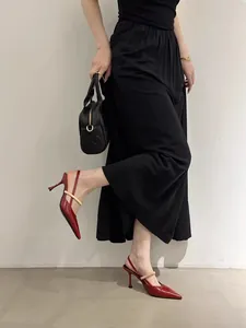 Elegant red pointed-toe slingback heels with a gold buckle strap shown on a model