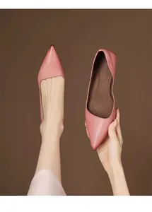 Detailed close-up of elegant pink pointed-toe kitten heel pumps being held and worn