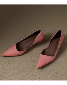 Elegant dusty pink pointed-toe kitten heel pumps featuring a stylish wavy edge design.