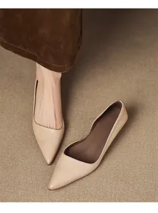 Close-up of elegant nude pointed toe kitten heel pumps with side cut-out