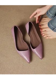 Elegant purple pointed-toe kitten heel pumps shown in a close-up detail on a textured mat