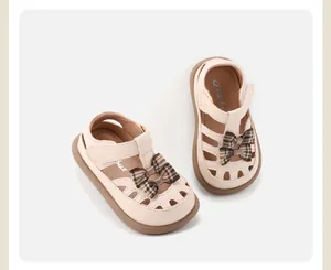 Detailansicht cremefarbener Kleinkind-Sandalen für Mädchen mit Karo-Schleife und Cut-outs