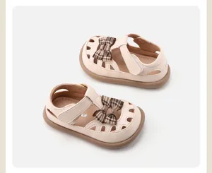 Detailansicht der beigen Sandalen für Kleinkinder mit karierter Schleife und Gummisohle