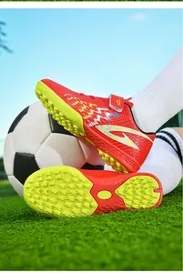 Dettaglio scarpe da calcio TF rosse e gialle per bambini con chiusura a strappo