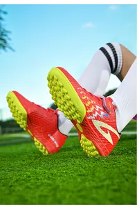 Vista dettagliata di scarpe da calcio rosse per bambini con tacchetti TF gialli antiscivolo.