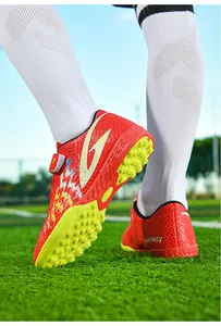 Dettaglio scarpe calcio TF rosse bambini con tacchetti gialli antiscivolo e velcro