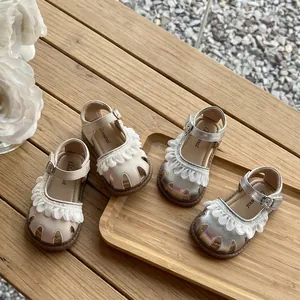 Gros plan de sandales de princesse à volants pour fillettes en crème et argenté