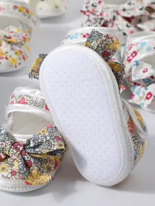 Detailansicht weißer Baby-Blumenschuhe mit rutschfester Weichsohle und passendem Stirnband