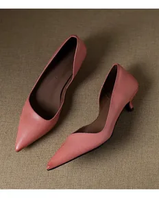 Macro detail of elegant pink pointed-toe kitten heel pumps with side cutout design