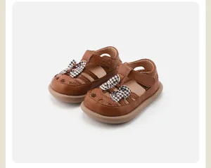 Detailansicht der braunen Leder-Sandalen für Mädchen mit stilvollen karierten Schleifen