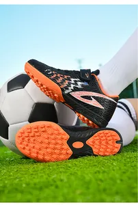 Dettaglio ravvicinato delle scarpe da calcio TF per bambini con suole antiscivolo arancioni