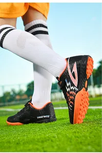 Scarpe da calcio per bambini per erba sintetica con suola arancione antiscivolo