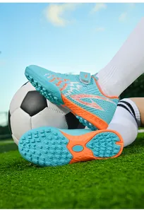Dettaglio scarpe da calcio bambino blu con tacchetti TF e cinturino velcro su erba