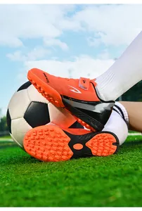 Vue détaillée de chaussures de foot TF orange avec semelles à crampons sur gazon