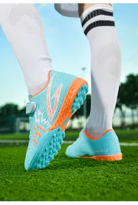 Dettaglio ravvicinato di scarpe da calcio blu per bambini con tacchetti TF su erba
