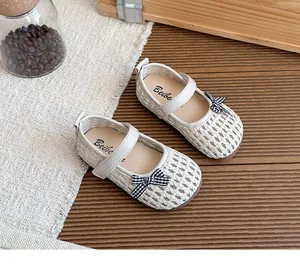 Detailaufnahme von geflochtenen, hohlen Kinder-Mary-Janes mit karierten Schleifen