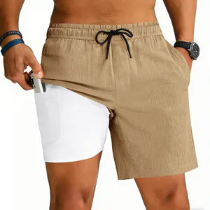 Detalle de pantalones cortos running 2 en 1 caqui con bolsillo para móvil en forro blanco