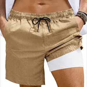 Primer plano de pantalones cortos deportivos 2 en 1 caqui con capa interior.
