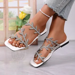 Elegant square toe flat sandals featuring sparkling rhinestone leaf-shaped straps for summer